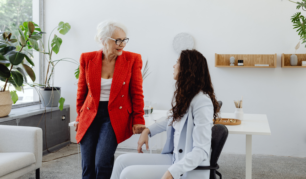 Immagine che raffigura l'essenza del mentoring aziendale: si vede una donna più anziana che parla con una collega più giovane.